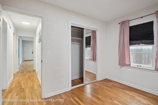 900 Holten St, Lansing, MI 48915 - unfurnished bedroom with light wood finished floors, a closet, and baseboards