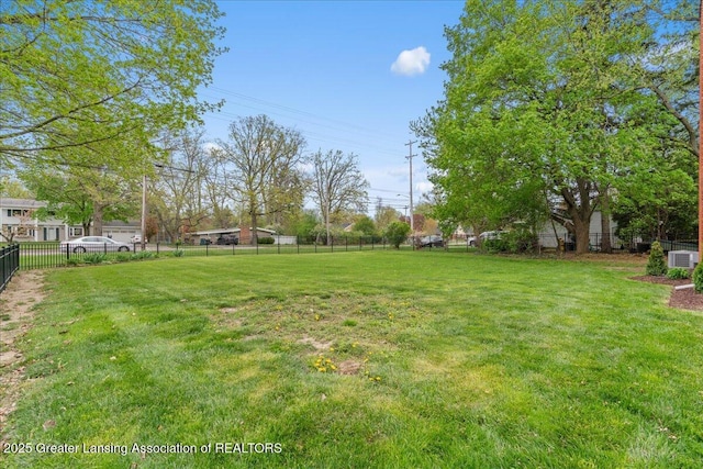 view of yard featuring central air condition unit and fence