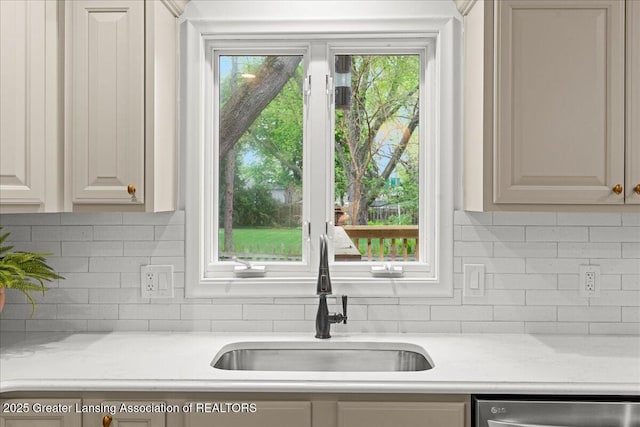 kitchen with backsplash, a sink, and dishwasher