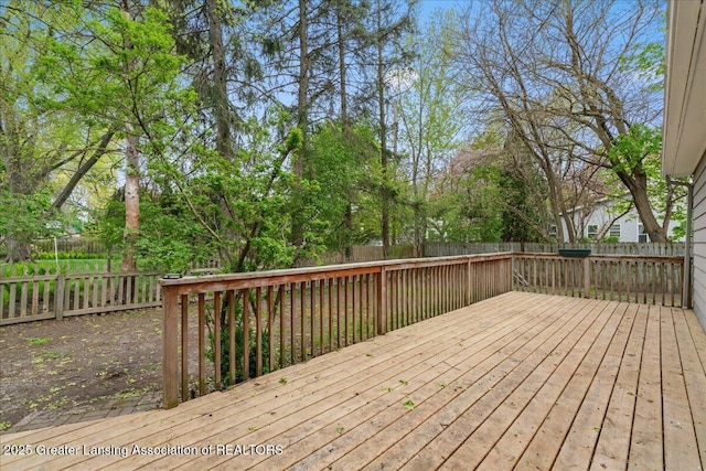 wooden terrace with a fenced backyard