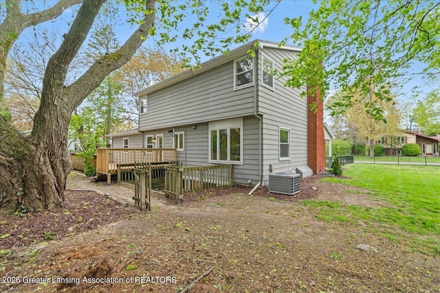 rear view of property featuring a yard, a wooden deck, cooling unit, and fence
