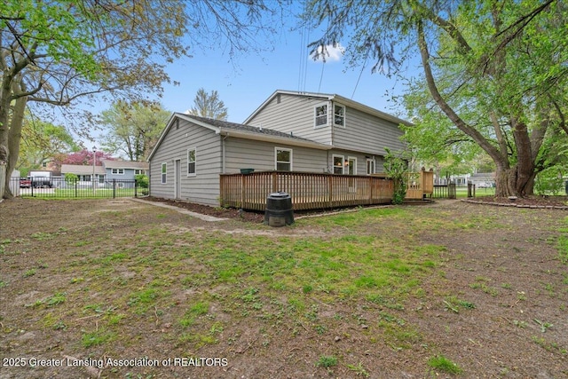 back of property with fence and a deck