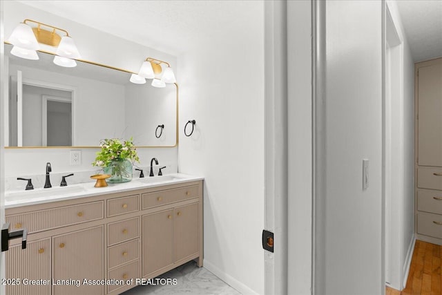 full bath featuring double vanity, baseboards, and a sink