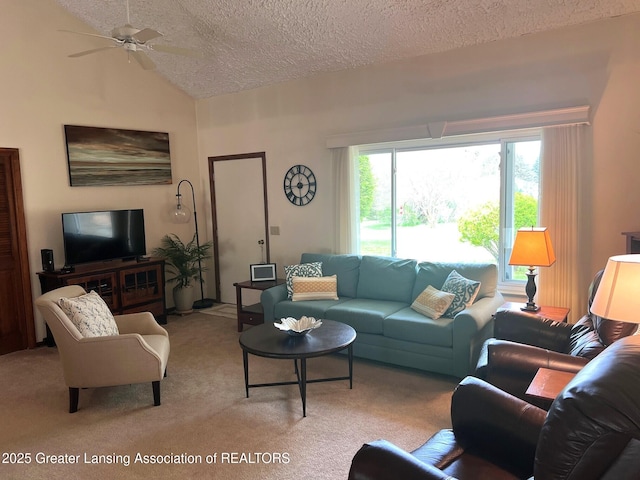 living room featuring a textured ceiling, healthy amount of natural light, carpet, ceiling fan, and lofted ceiling