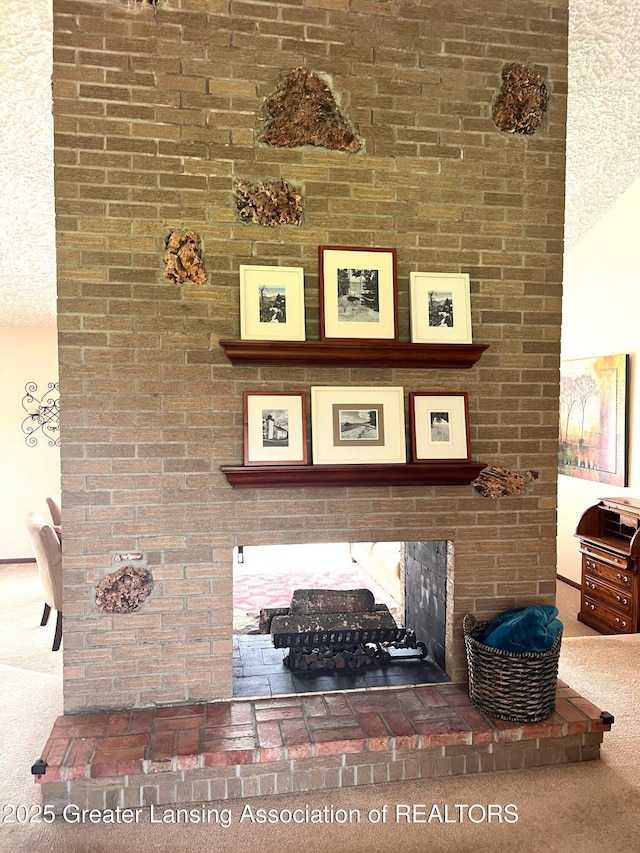 detailed view of carpet and a brick fireplace