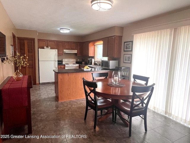 dining room with dark tile patterned flooring and arched walkways