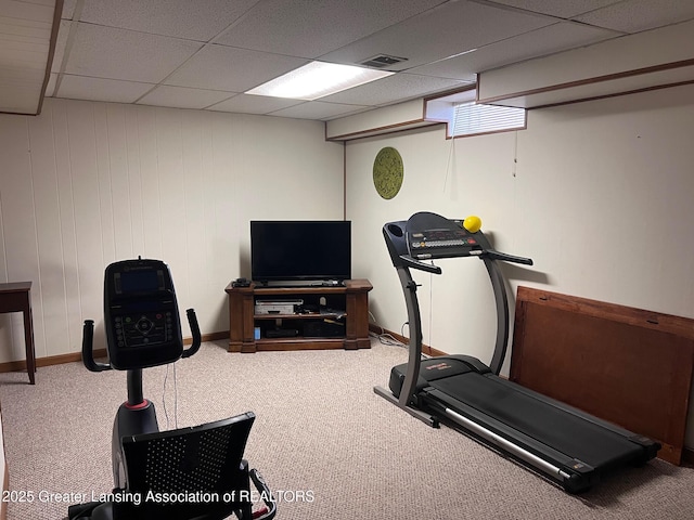 exercise room featuring carpet floors, a drop ceiling, and baseboards