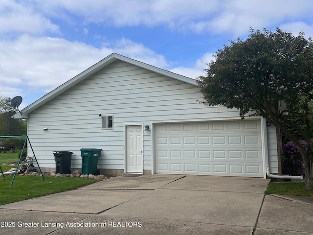 view of side of home featuring a garage and concrete driveway