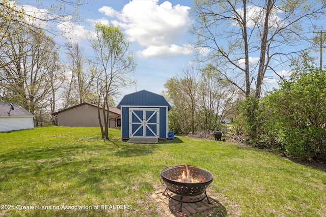 view of yard with an outdoor fire pit, an outdoor structure, and a shed