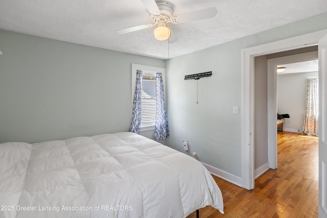 bedroom with baseboards, a ceiling fan, and wood finished floors