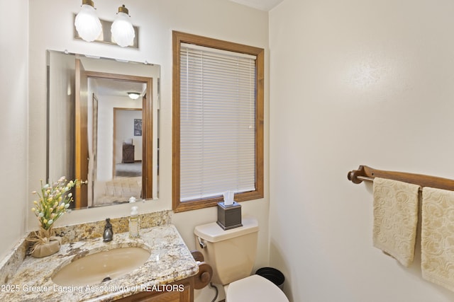 half bathroom featuring toilet and vanity