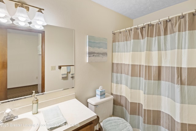 full bath with vanity, toilet, curtained shower, and a textured ceiling