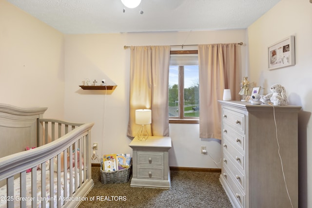 bedroom featuring baseboards, dark colored carpet, and a crib