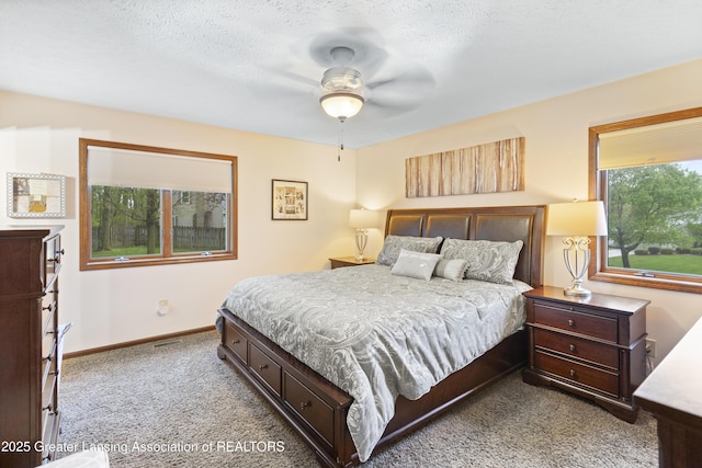 carpeted bedroom featuring baseboards and a ceiling fan