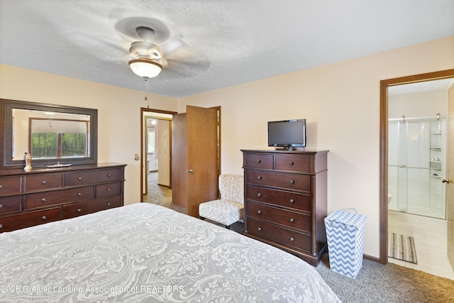bedroom with carpet floors, a textured ceiling, ensuite bath, and a ceiling fan