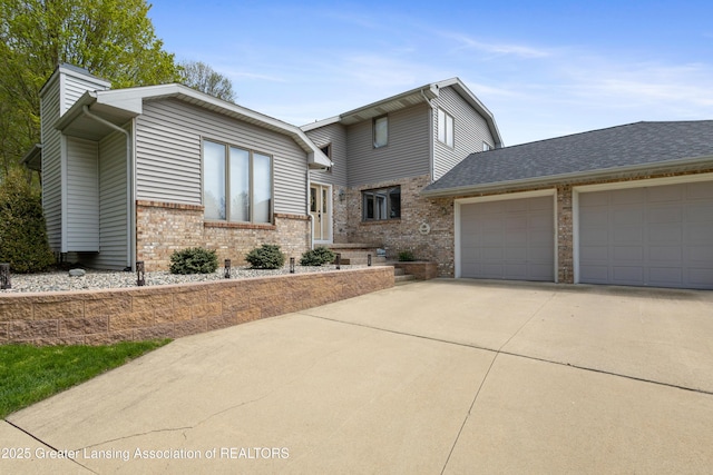 view of front of property featuring brick siding, driveway, and an attached garage
