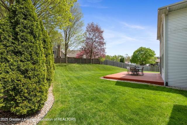 view of yard featuring a wooden deck and outdoor dining space