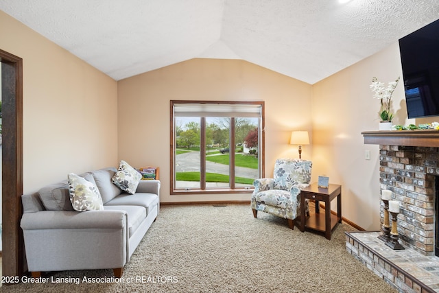 living room with carpet floors, a brick fireplace, vaulted ceiling, baseboards, and a textured ceiling