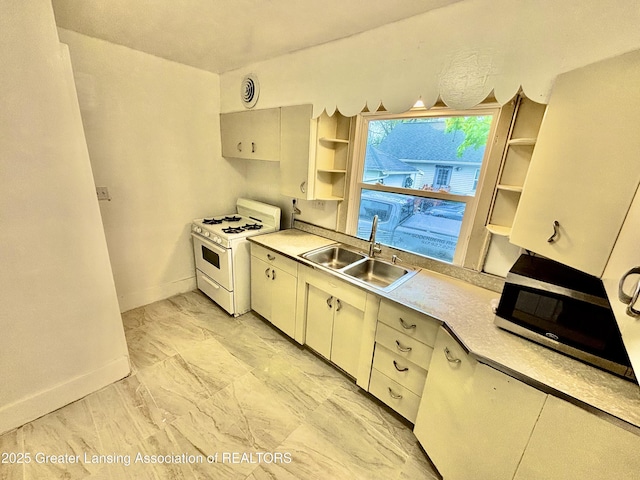 kitchen with a sink, open shelves, stainless steel microwave, baseboards, and gas range gas stove