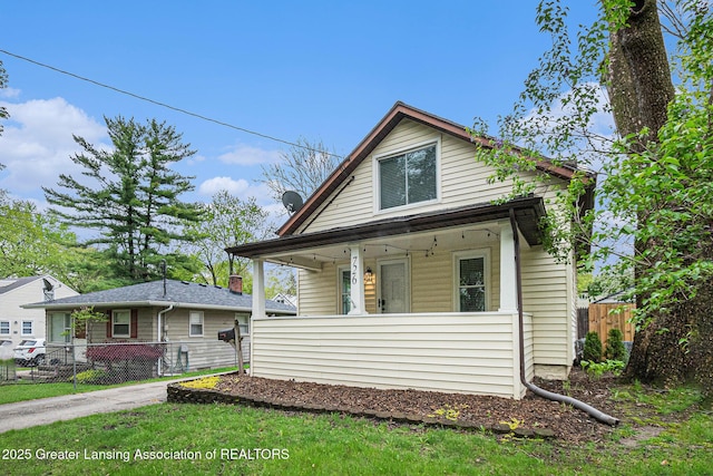 bungalow-style house featuring a porch and fence