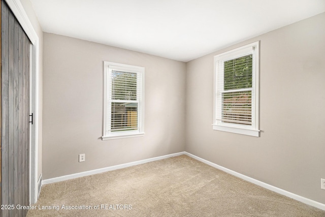 unfurnished bedroom with a closet, multiple windows, baseboards, and carpet floors