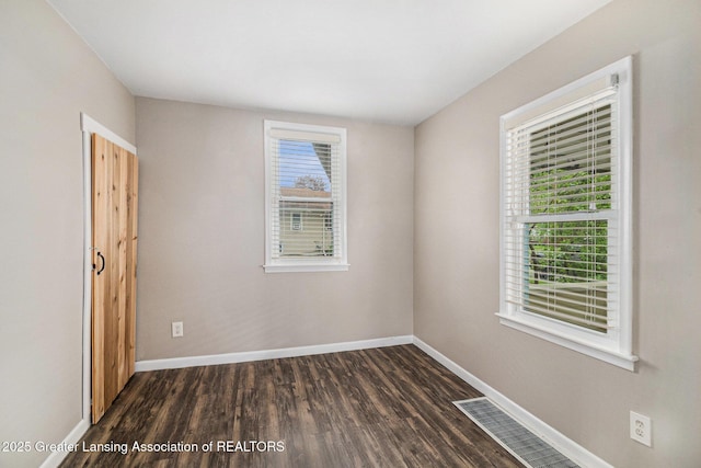 unfurnished room featuring dark wood finished floors and baseboards