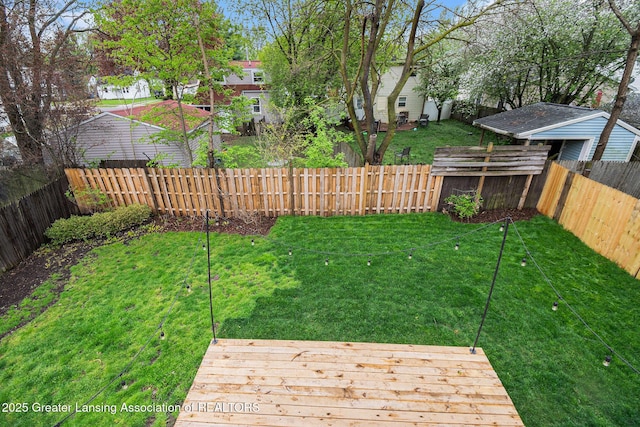 view of yard with a wooden deck, a residential view, and a fenced backyard