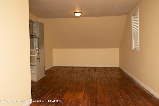 bonus room featuring dark wood-style flooring and baseboards