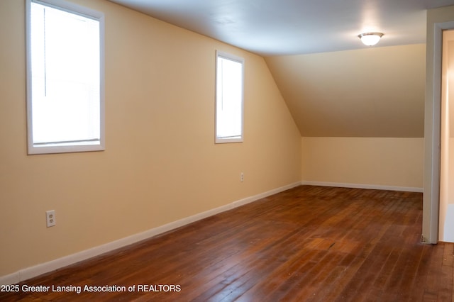 additional living space with hardwood / wood-style floors, lofted ceiling, and baseboards