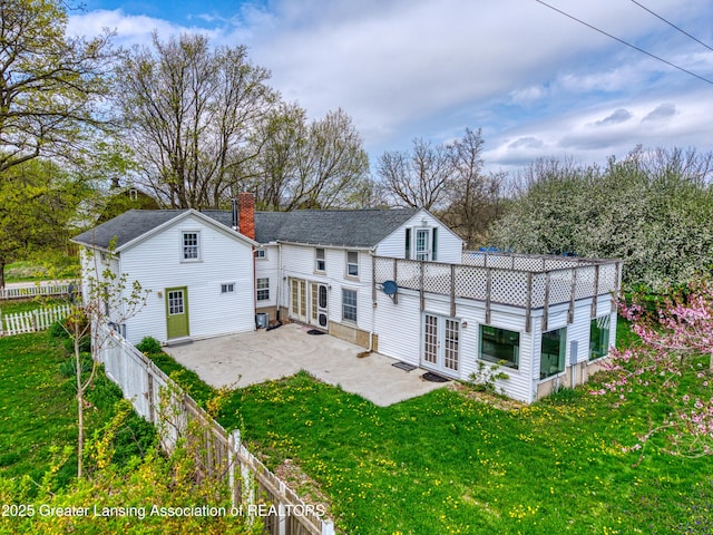 2820 N Lima Center Rd, Dexter, MI 48130 - back of property with a chimney, a patio, french doors, and a lawn
