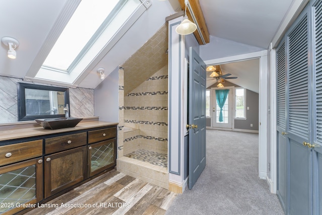 2820 N Lima Center Rd, Dexter, MI 48130 - bathroom with a ceiling fan, vaulted ceiling with skylight, baseboards, walk in shower, and vanity
