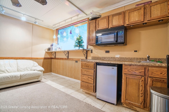 2820 N Lima Center Rd, Dexter, MI 48130 - kitchen with freestanding refrigerator, rail lighting, black microwave, brown cabinets, and light countertops