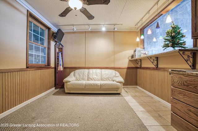 2820 N Lima Center Rd, Dexter, MI 48130 - sitting room featuring a wainscoted wall, track lighting, ceiling fan, wooden walls, and light tile patterned floors