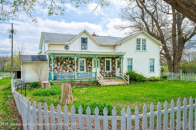 2820 N Lima Center Rd, Dexter, MI 48130 - view of front of property with a front yard, a shingled roof, covered porch, and a fenced backyard