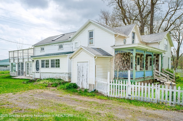 2820 N Lima Center Rd, Dexter, MI 48130 - view of front of property with a fenced front yard, roof with shingles, and a porch