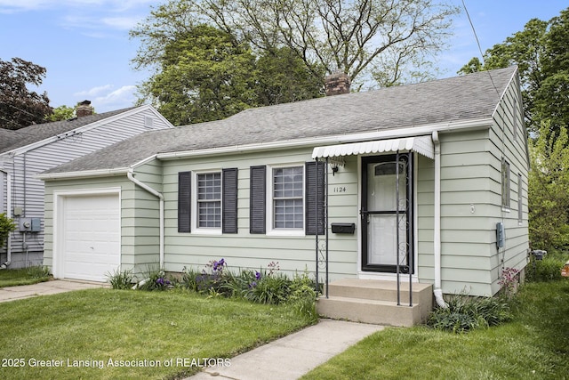1124 Poxson Ave, Lansing, MI 48910 - view of front of property featuring a garage, a front yard, a chimney, concrete driveway, and a shingled roof