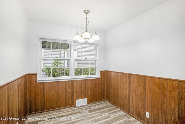 1124 Poxson Ave, Lansing, MI 48910 - unfurnished dining area featuring a wainscoted wall, a chandelier, wooden walls, crown molding, and wood finished floors