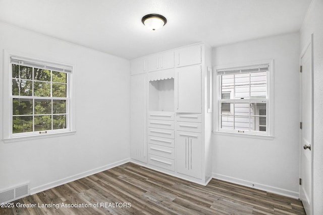 1124 Poxson Ave, Lansing, MI 48910 - unfurnished bedroom with dark wood finished floors, a closet, baseboards, and crown molding