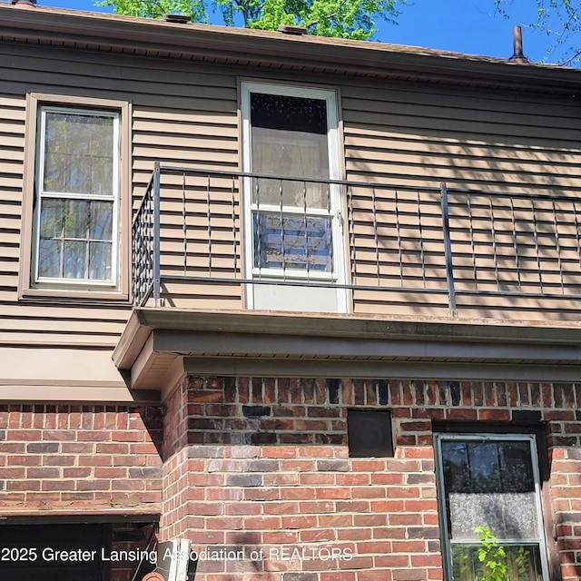 view of property exterior with brick siding and a balcony