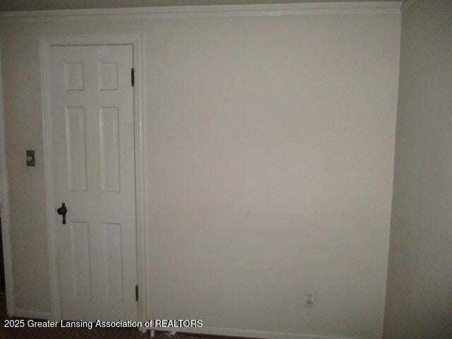 empty room featuring crown molding