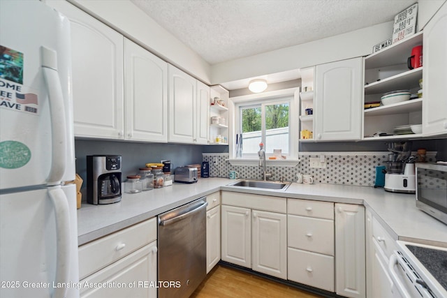 kitchen with open shelves, appliances with stainless steel finishes, a sink, white cabinets, and a textured ceiling