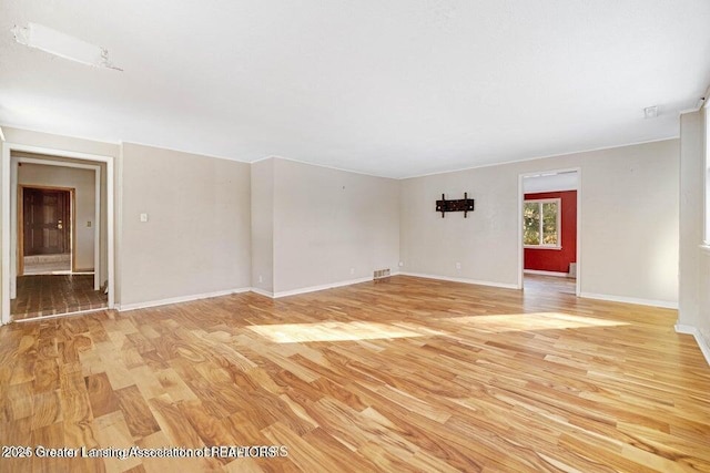 spare room featuring light wood-style flooring and baseboards