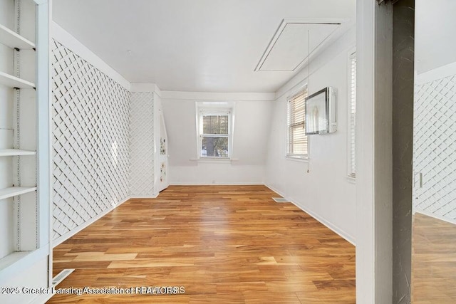 spare room with attic access and light wood-style flooring