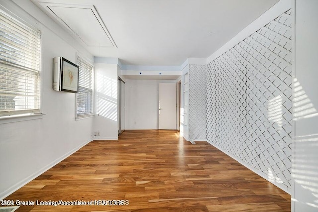 empty room with attic access and wood finished floors