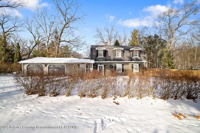 snow covered rear of property featuring a chimney
