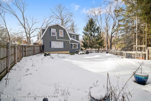 snowy yard featuring a fenced backyard