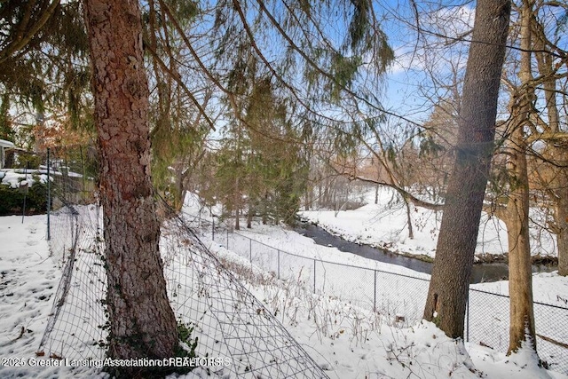yard covered in snow with fence