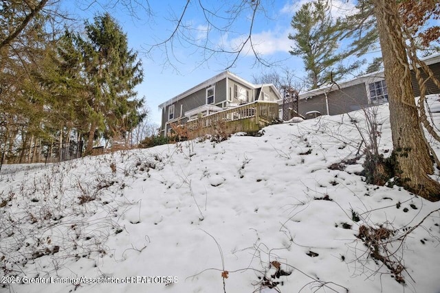 yard covered in snow featuring a wooden deck