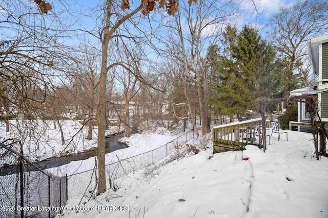 snowy yard featuring fence