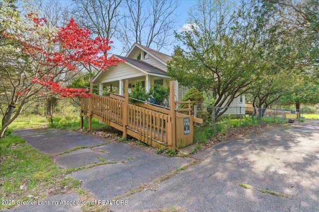 view of home's exterior featuring covered porch and fence